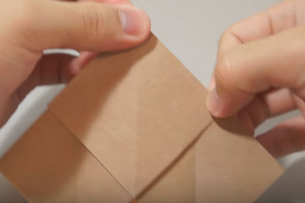 Mở các góc giấy thừa ra để vuốt nếp