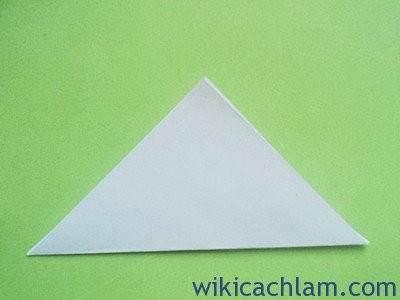 Bước 1: Cắt giấy thành hình vuông rồi gấp chéo thành hình tam giác. Kích thước tùy theo bạn muốn hoa to hay nhỏ.