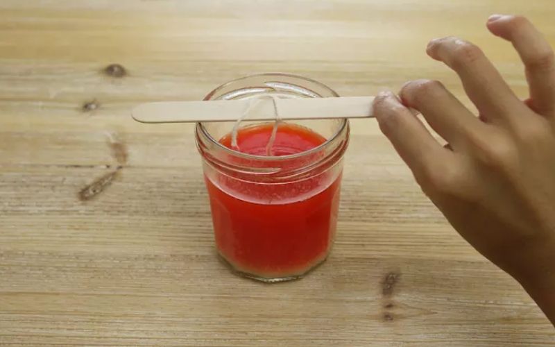 Step 3 + 4: Put the essential oil in and plug the wick into the middle of the glass jar