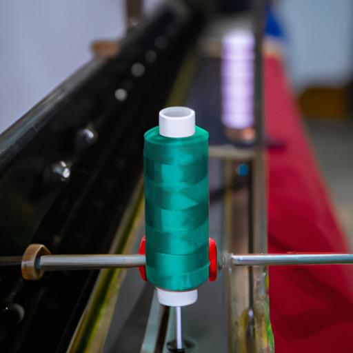 Gần cận về cuộn chỉ được đưa vào máy may tại một nhà máy dệt may ở Việt Nam.