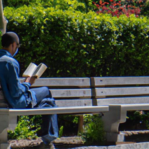 Người ngồi trên ghế đọc sách trong công viên.
